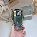 Paco Rabanne Invictus teal trophy bottle held in hand